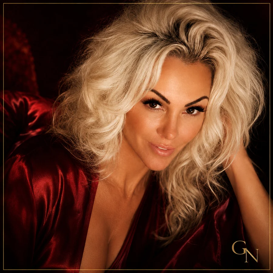 Gigi Nicole artist portrait with platinum curls and a crimson velvet neckline